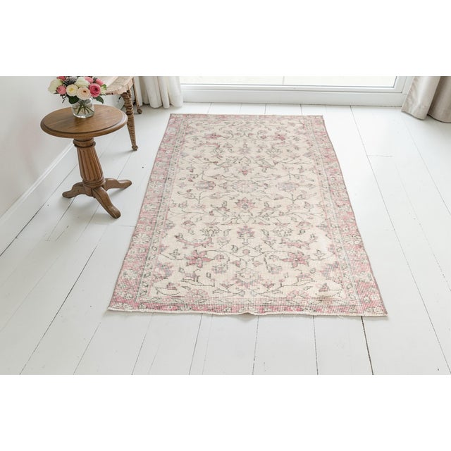 This is a vintage Turkish Oushak rug from the Mid 20th Century. The piece was hand-knotted.