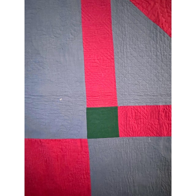 A large Amish quilt of center diamond pattern made from a red, green and light blue fine wool and cotton blend and backed...