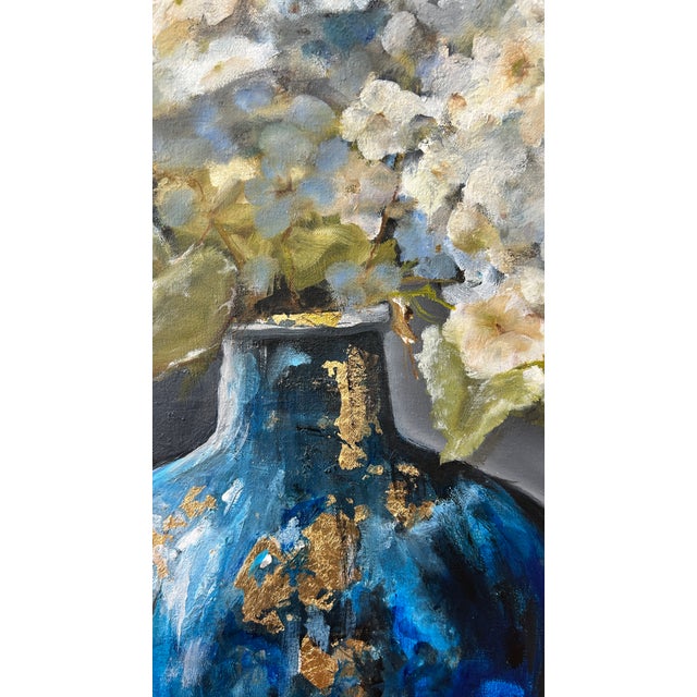A striking original floral still life painting featuring a vivid blue vase filled with lush white and blue hydrangeas...