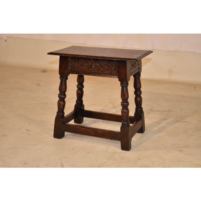 Mid-19th-century hand carved decorated oak joint stool from England. The top has a beveled edge and follows down to a hand...