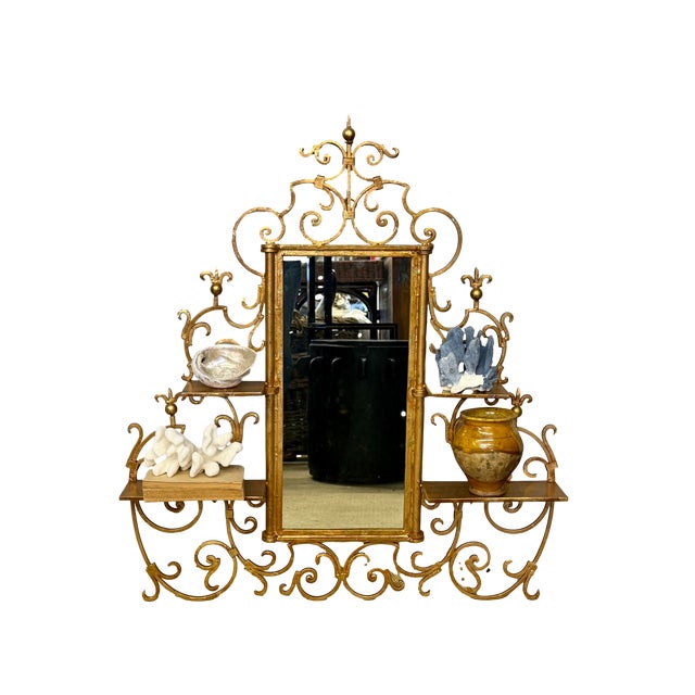 An exceptional mid-20th-century Italianate gilt iron wall mirror and etagere, elaborately fashioned with scrolling...
