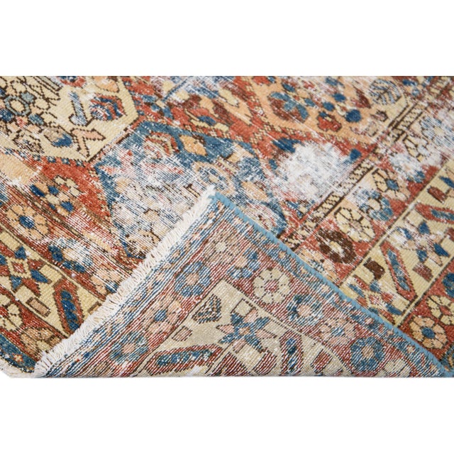 Beautiful Vintage Geometric Distressed hand-knotted wool rug with a rust field. This rug has blue and beige accents all-...