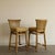 A handsome pair of McGuire counter stools combining a bleached rattan pole frame with a densely woven rawhide back panel....