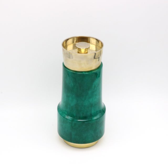 An Aldo Tura Modernist cocktail shaker. Green colored parchment with silver and brass plated details.