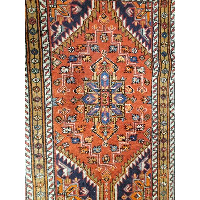 Circa 1975 Runner features a bold geometric medallion pattern set against a vibrant brick-red field. it displays...