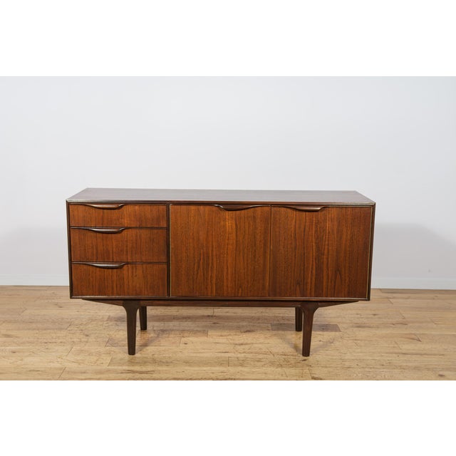 This elegant sideboard was manufactured in the 1960s by the renowned scottish furniture maker a.h. Mcintosh & co. Of...