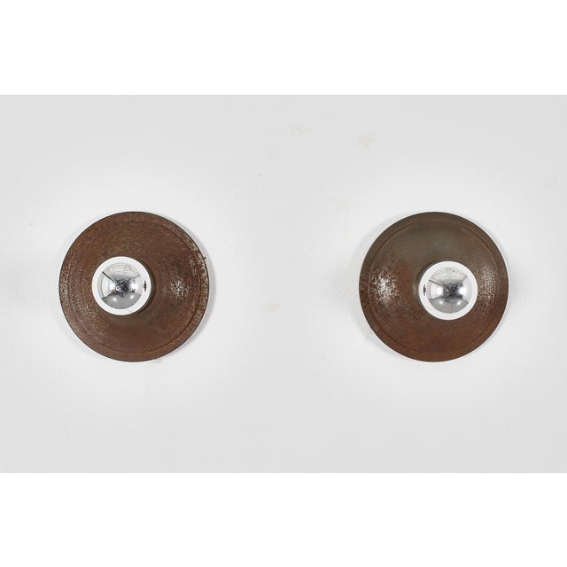Pair of turned bronze wall lamps. In the style of Angelo Mangiarotti, Italian production from the 1960s. Wear consistent...
