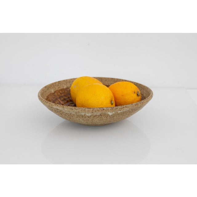 A charming small-scale ceramic bowl produced by Michael Andersen & Søn, Denmark 1960s. This piece features a warm, rustic...