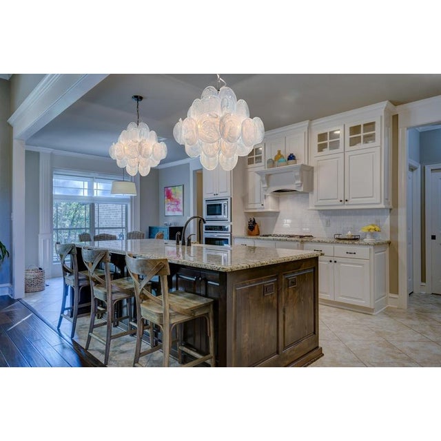 Pair Italian Murano chandeliers. The chandelier has 36 fantastic iridescent alabaster blue discs in a nickel metal frame....