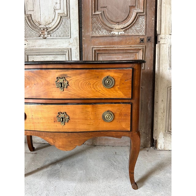 A cherrywood commode after a design by jean françois hache, circa 1900. The front opens to reveal two drawers with bronze...