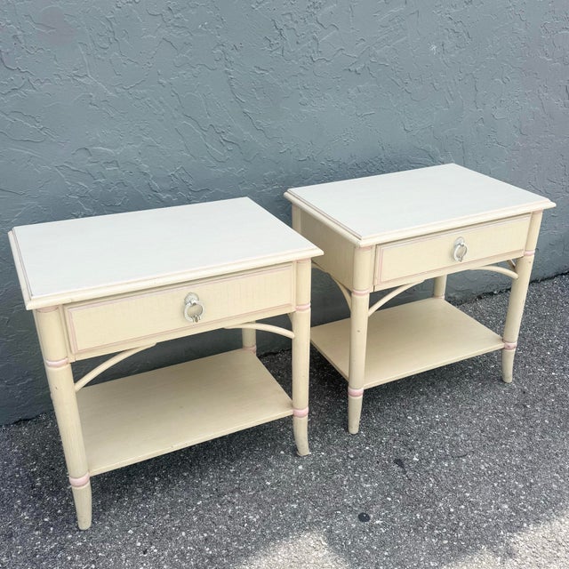 A charming pair of vintage Thomasville nightstands, beautifully designed in a soft coastal palette of creamy ivory with...
