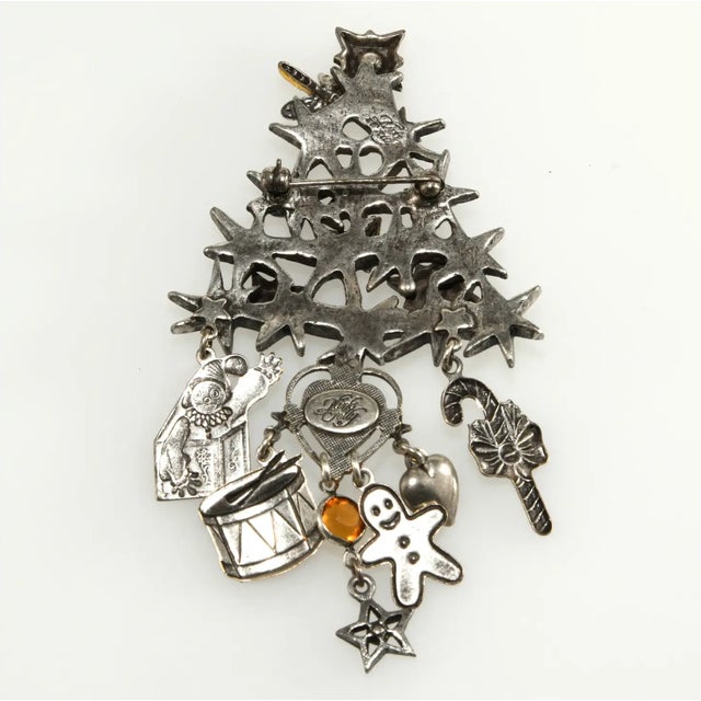 Christmas tree pin with stars in the metal work decorated with red, green, and yellow rhinestones. Has layered elements,...