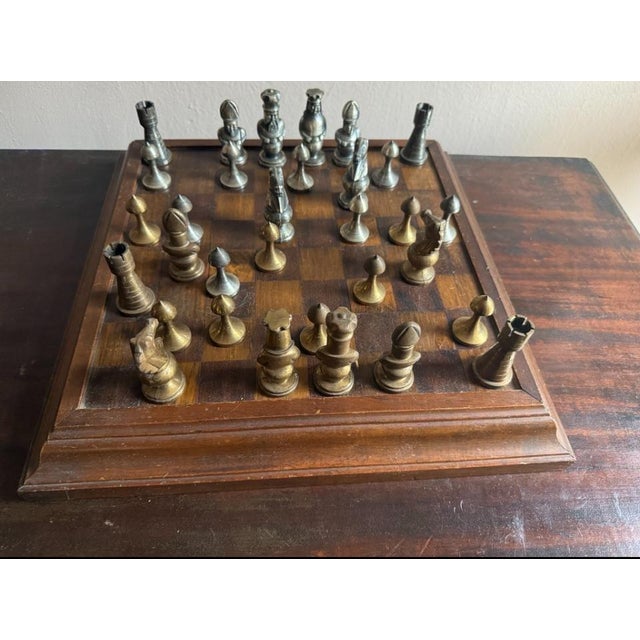 Decorative Mid 20th Century chess set with handcrafted cast metal chess pieces in Medieval style and a wooden chess board....