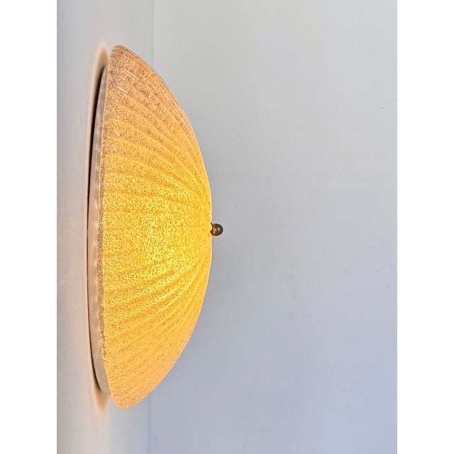 A striking wall sconce featuring a Murano glass diffuser, produced in Italy in the 1970s. Classic and timeless design,...