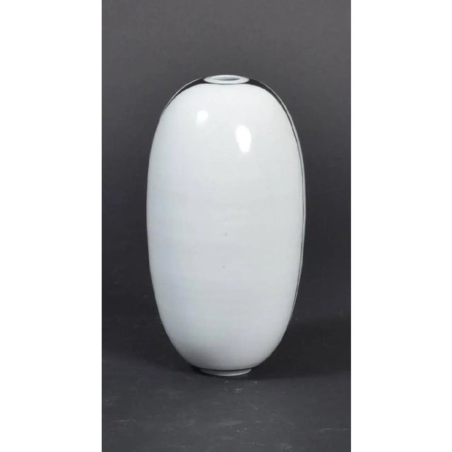 This large Danish porcelain vase features minimalist decorations and is signed at the bottom.