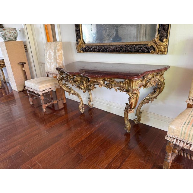 French mid-18th century gilt-wood and lacquered Louis XV console with a french red veneered marble top , above a pierced...