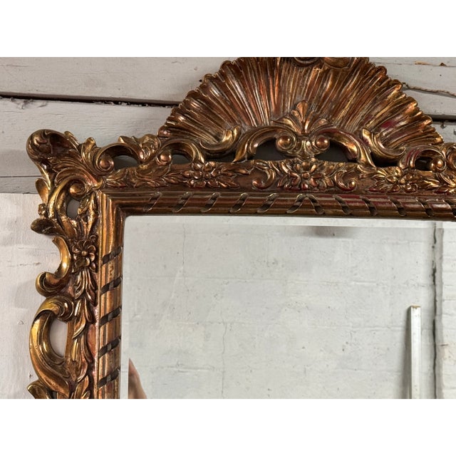 French Regency Style Gilt Mirror with high pediment and scrolling design. Made in the Mid 20th Century.