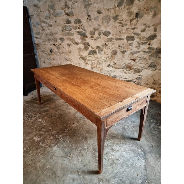 This antique French farmhouse dining table dates from the late 19th century (circa 1850–1900). The table features a solid...
