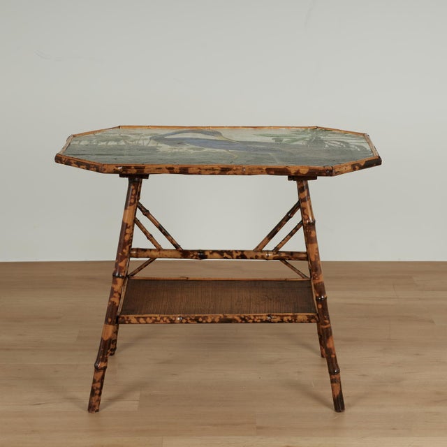 Lofty 19th century English table crafted in burnt bamboo grasscloth on two tiers, featuring a later decoupage tropical...