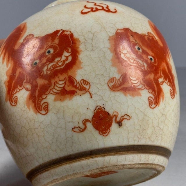 Charming small Chinese lidded ginger jar with creamy off-white crackle glaze finish. Hand decorated in striking iron red...