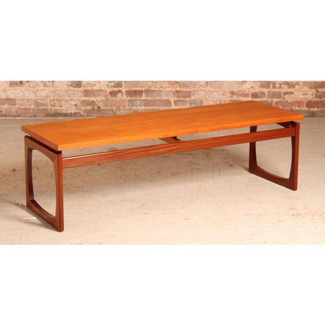 A mid century g-plan quadrille long coffee table crafted from teak, dating back to the 1960s. This piece has been...