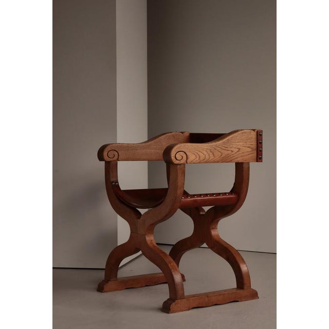A striking Danish Art Nouveau armchair in the Kurul style, handcrafted in solid oak and saddle leather, dating to the...