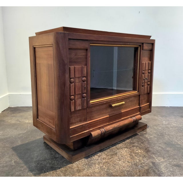 1940's French mahogany sideboard with carved geometric pattern doors, plinth base and tapered edge top. Gold trim...