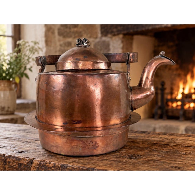 A beautifully aged 19th-century copper kettle with the irregularities and hand-worked details that make early utilitarian...