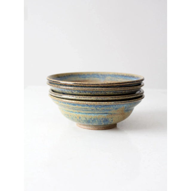 A beautiful set of four vintage studio pottery bowls, each signed by the artist. Handcrafted with a striking blue and...