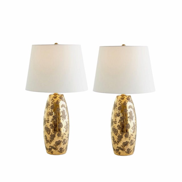 A striking pair of Global Views “Shiny Barrel” table lamps, crafted in Italy and finished in a richly layered gold leaf...