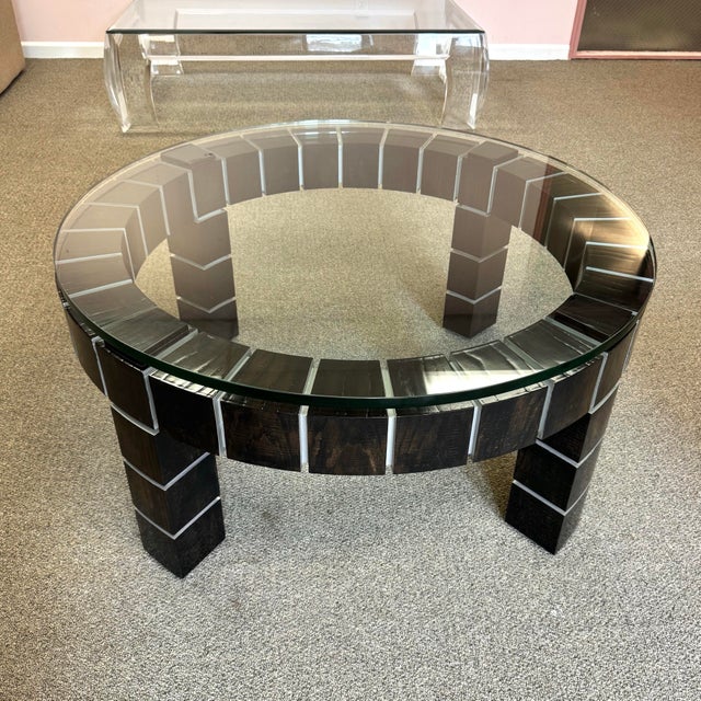 A fantastic circular postmodern coffee table. The base is constructed of square dark wood blocks, with silver joints. The...
