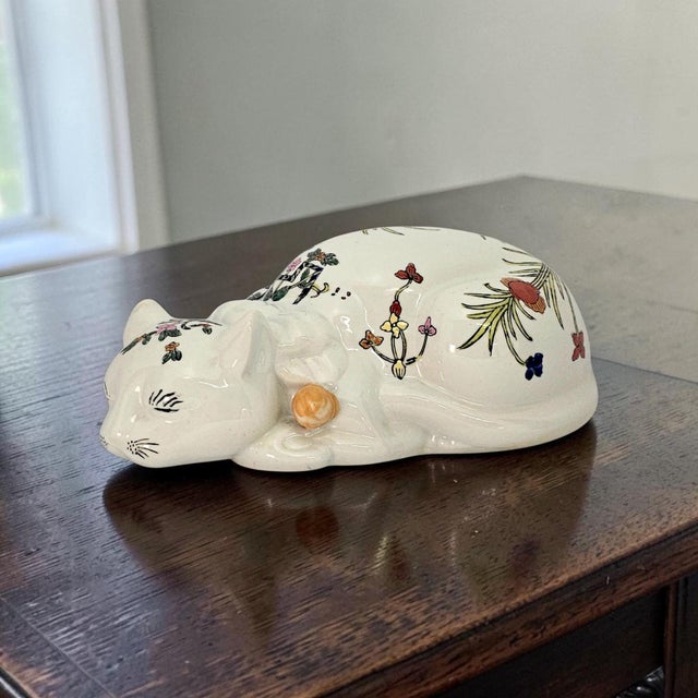 A mid-twentieth-century Chinese ceramic cat figurine, circa 1950s–1970s, modelled in a reclining or sleeping pose with...
