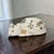 A mid-twentieth-century Chinese ceramic cat figurine, circa 1950s–1970s, modelled in a reclining or sleeping pose with...