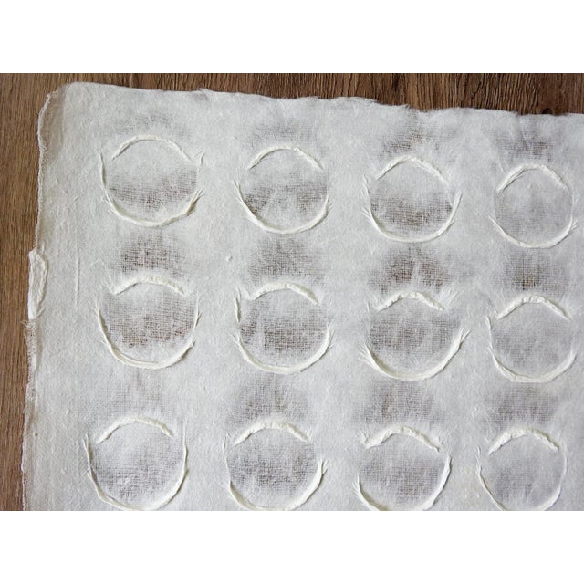Late 20th century white handmade paper with overall relief sculptural circle pattern. Paper has loose fabric...