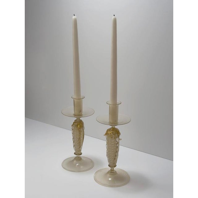 A pair of handcrafted Murano glass candlesticks by Gabbiani, created in Murano, Italy during the late 20th century....