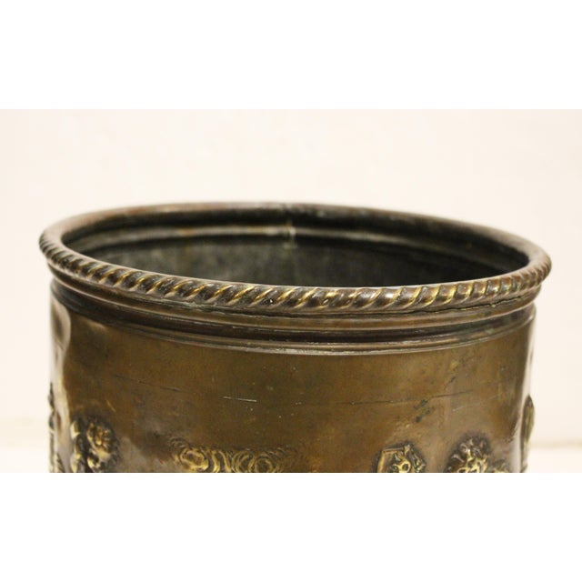 Mid-19th century circular brass jardiniere, French. Roped collar. The repousse motifs are of cherub artists at work in...