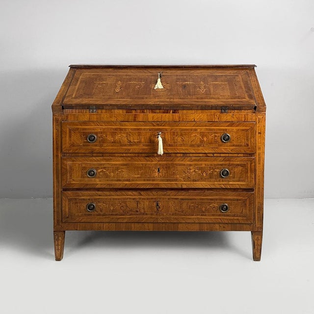 Inlaid wood drop-leaf chest of drawers. The drop-leaf features four drawers with round brass handles, two shelves and a...