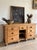 A long English pine knee-hole sideboard, the plank top worn to a warm honey colour over banks of drawers either side of a...