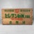 Decorative Japanese wooden transport crate from the 1950s, featuring vivid green and red lettering. The text refers to an...