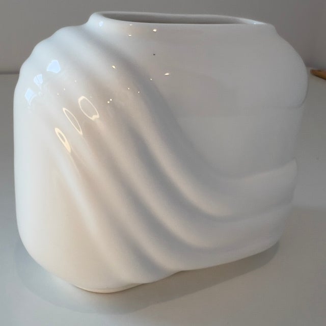 Postmodern Art Deco Revival style, characterized by the geometric swish or wave. Glossy white glazed ceramic.