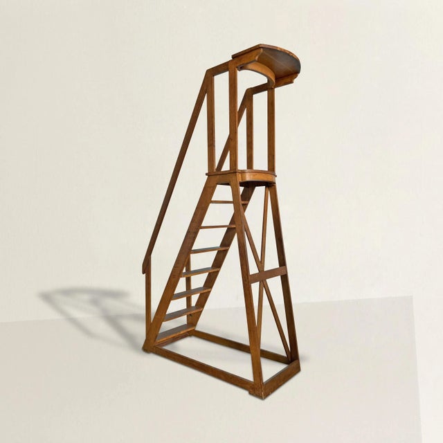 A monumental and sculptural early 20th century French oak library ladder with eight steps, handrails, and a shelf at the...