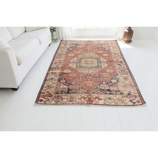 This is a vintage Turkish Oushak rug from the Mid 20th Century. The piece was hand-knotted.