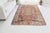 This is a vintage Turkish Oushak rug from the Mid 20th Century. The piece was hand-knotted.