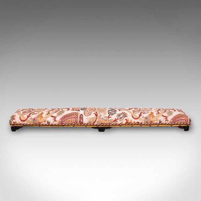 This is a long antique carriage stool. An English, mahogany and Crewelwork textile fireside foot rest in aesthetic period...