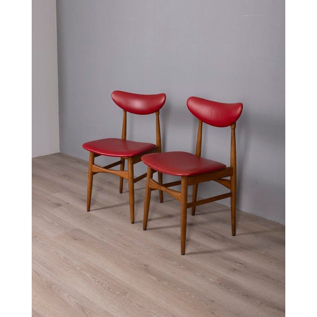 Pair of chairs with wooden frame and red faux leather upholstery, Italian design, 1960s.