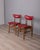 Pair of chairs with wooden frame and red faux leather upholstery, Italian design, 1960s.