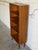 This tall teak bookcase by Poul Hundevad pairs a narrow profile with four open shelves and five display levels. Clean...