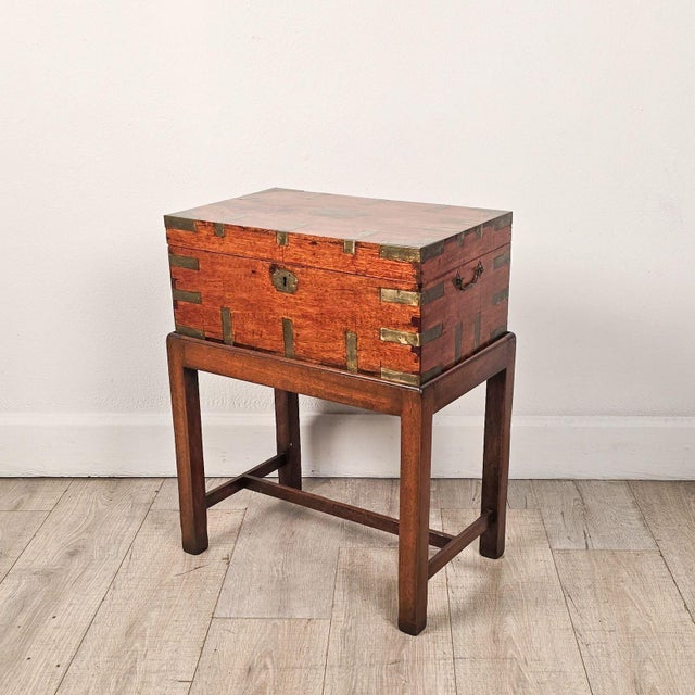 An early 19th-century Anglo-Indian camphor brass-mounted campaign trunk. The box on its own measures 7.75" h x 19" w x...