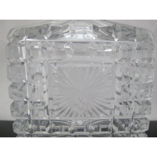 Fine liquor decanter in rectangular form. Has clear heavy cut crystal square texture with burst at center. Measures 8.75"...