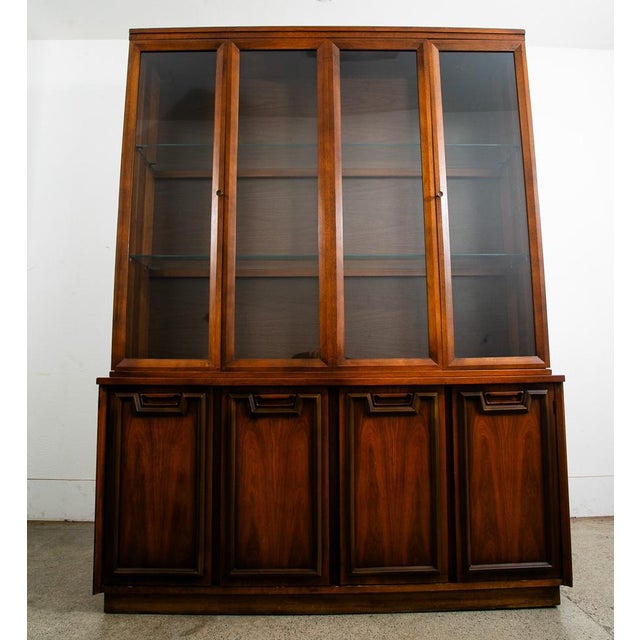 Mid Century Modern walnut display hutch / china cabinet in a unique design. This piece was created and sold by Garrison...
